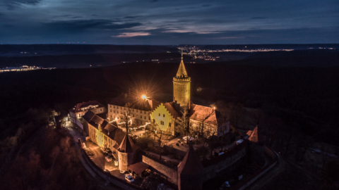 Luftaufnahme der Leuchtenburg bei Nacht mit Jena am Horizont © Stiftung Leuchtenburg, Foto: Daniel Suppe