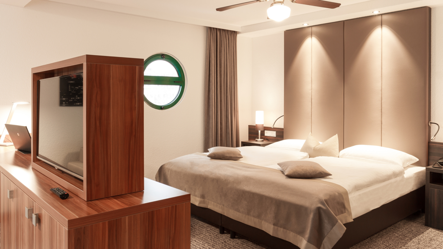 Maxx Hotel, Suite Doppelsuite mit Bullaugenfenster, Deckenventilator und Flatscreen auf der Kommode