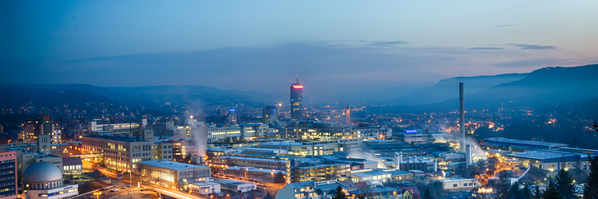 Stadtansicht vom Waldrand auf das beleuchtete Zeiss und Schott Gelände © JenaKultur , Foto: André Gräf