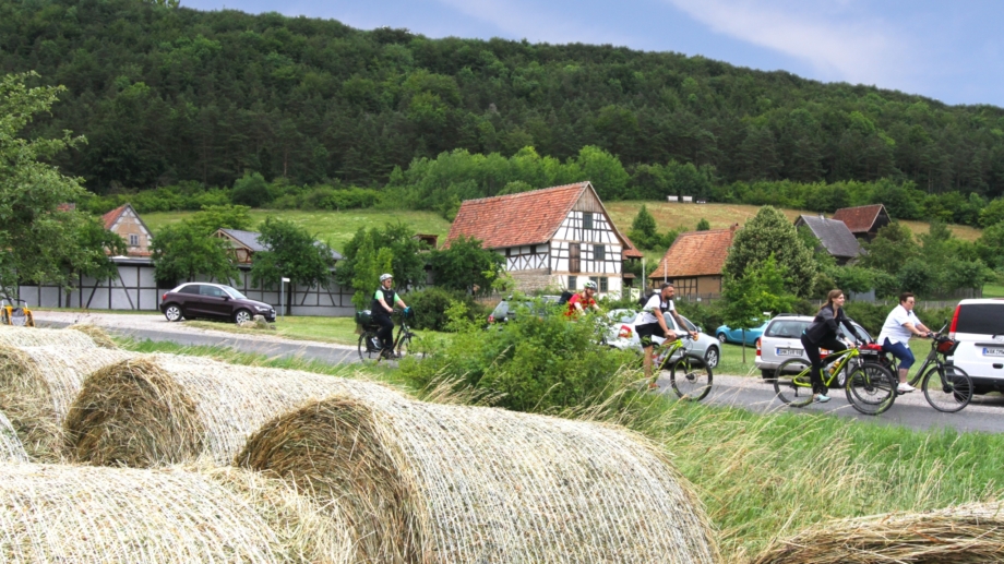 © Landratsamt Weimarer Land, Foto: Uwe Germar Radfahrer vor dem Thüringer Freilichtmuseum Hohenfelden mit Strohballen im Vordergrund © Landratsamt Weimarer Land, Foto: Uwe Germar