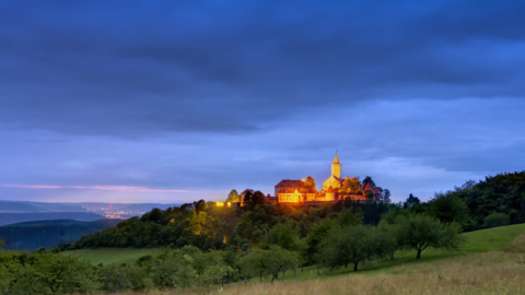 Blick auf die Leuchtenburg während der Dämmerung mit Jena im Hintergrund