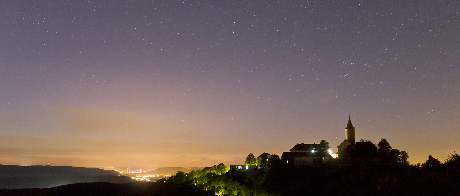 Blick auf die Leuchtenburg unter Sternenhimmel mit Lichtstadt Jena im Hintergrund - Ausflüge rund um Jena © Stiftung Leuchtenburg, Foto: Alexander Schlotter