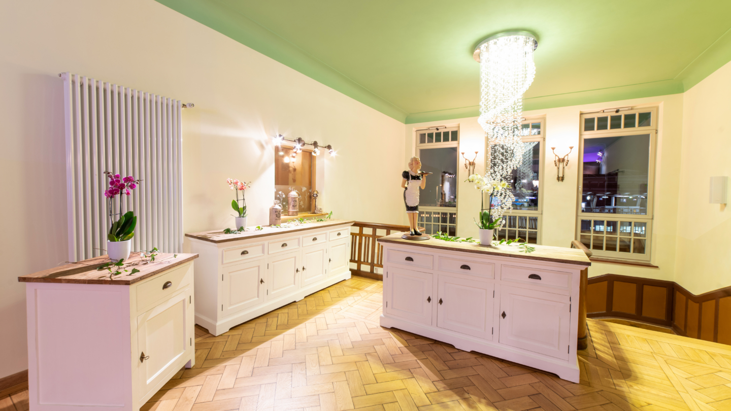 Villa am Paradies, Treppenabsatz © Arena Betriebsgesellschaft, Foto: Christoph Worsch Oberer Treppenabsatz der Villa am Paradies mit drei weißen Holzkommoden für das Catering (Buffet) © Arena Betriebsgesellschaft, Foto: Christoph Worsch