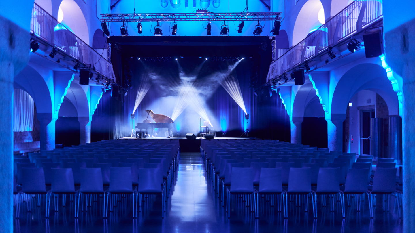 Blau ausgeleuchtete Badehalle kurz vor Beginn eines Konzerts