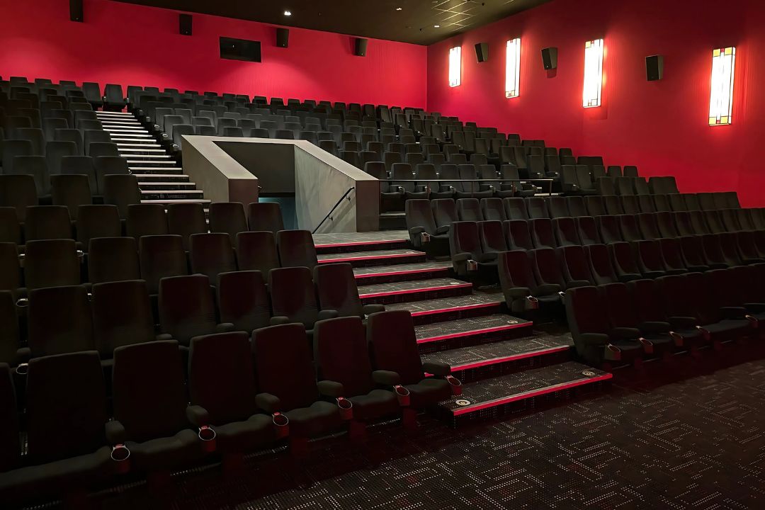 Kino 1 mit Blick auf die ansteigenden Stuhlreihen erstrahl in rotem Licht