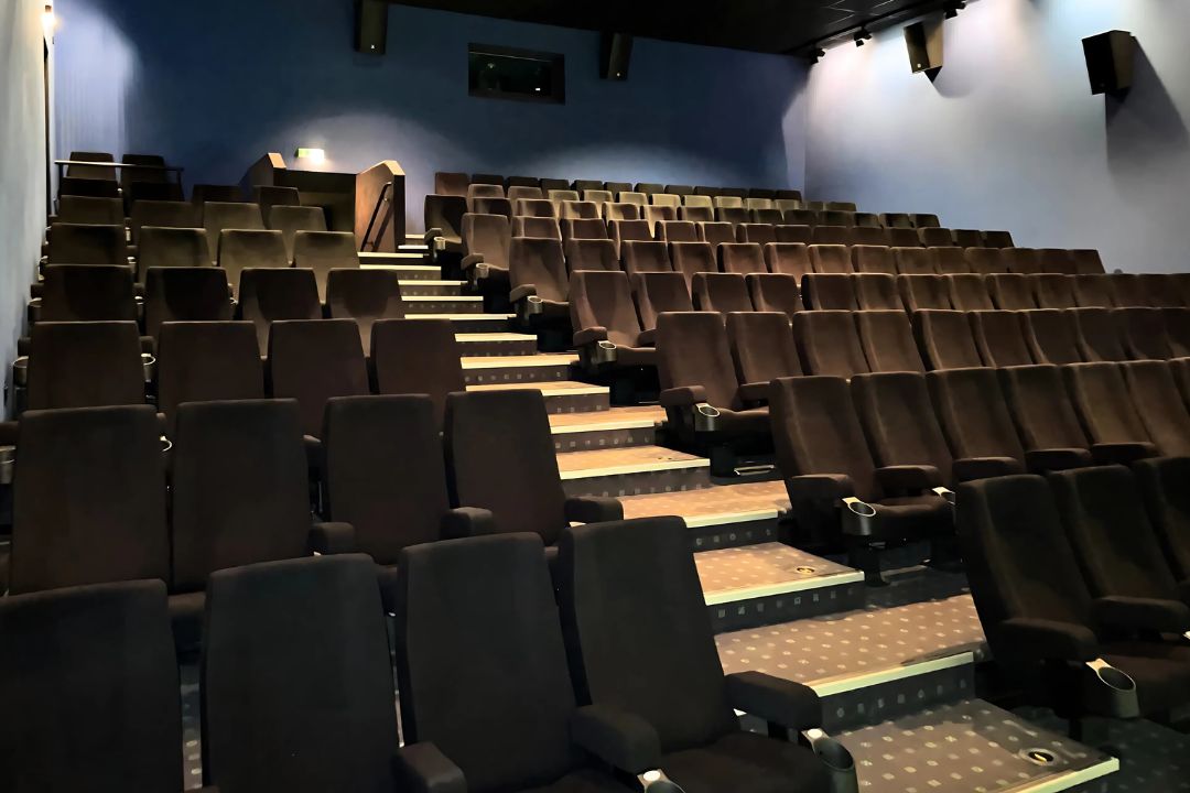 Das Kino 3 mit ansteigenden Sitzreihen und Blick zur Saaltür im Cinestar Jena