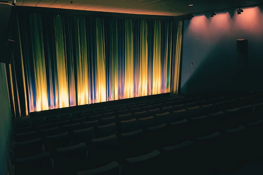 Gelbes und blaues Licht zaubern einen Streifeneffekt auf den Vorhang der Leinwand im Kino 3 des CineStars Jena
