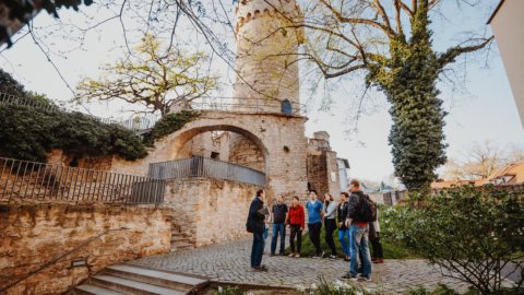 Eine Personengruppe bei einer Stadtführung durch Jena steht vor dem Pulverturm©JenaKultur_Siomotion
