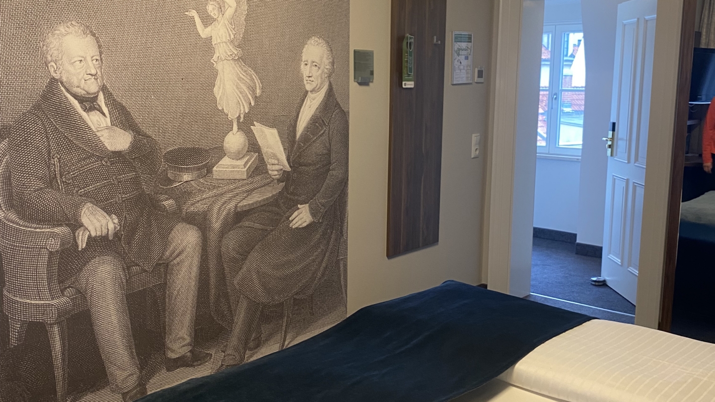 Impression eines Zimmers im Hotel Schwarz Bär in Jena mit einem Doppelbett und einem Wandgemälde ©JenaKultur_Foto: Jenny Marx